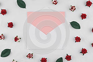 Pink card in white envelop decorate with red rose paper flowers