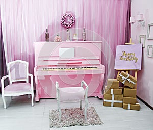 Pink chair. Happy Birthday inscription in golden letters. Gift boxes. Background for Photo Studio. Candles in a bottle