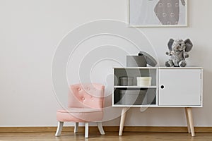 Pink chair next to white shelf