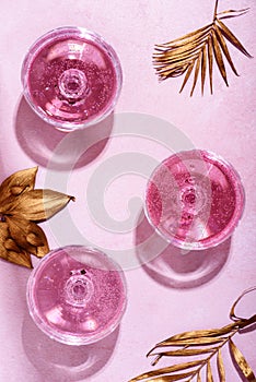Pink champagne in luxury crystal glasses and classy christmas decor. Top view. New year eve celebration and nightclub party with