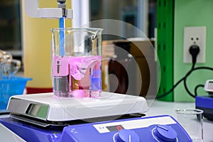 Pink chemical substance in beaker placed on magnetic stirrer