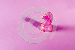 Pink chess piece horse isolated on a pink background