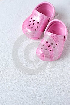 Pink child shoes and sunglasses on the beach, vacation vibe