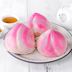 Pink Chinese peach birthday bun food on white table background