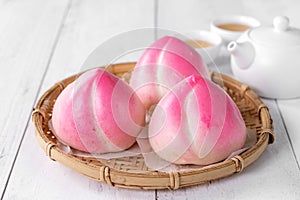 Pink Chinese peach birthday bun food on white table background