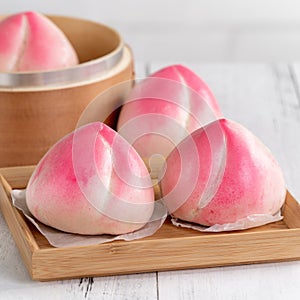 Pink Chinese peach birthday bun food on white table background