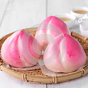 Pink Chinese peach birthday bun food on white table background