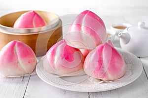 Pink Chinese peach birthday bun food on white table background