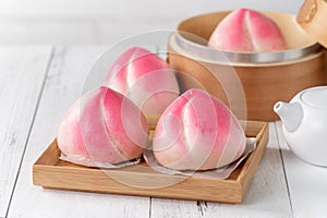 Pink Chinese peach birthday bun food on white table background