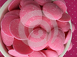 Pink Chocolate Candy Melts on pink polka dots Background