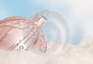 Pink christmas bauble in snow photo