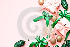 Pink Christmas card or New Year background, flat lay, copy space. Pastel pink gift boxes and green, golden decorations and