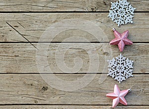 Pink Christmas decorative stars and silvery snowfields on a wooden background. Waiting for the holiday, a place for the