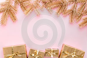 Pink Christmas or new year`s background,plain composition of golden Christmas gifts and golden fir branches, Flatlay,empty space