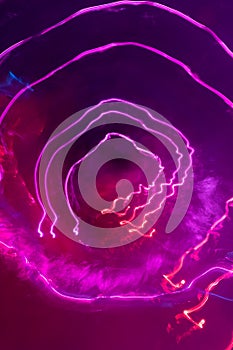 Pink circular electricity like light streaks on pink background