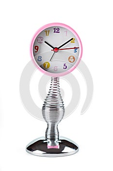 Pink clock with hands on a flexible spring. Front view.