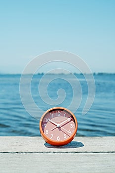 pink clock on a pier on a summer day