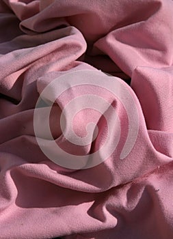 Pink cloth table napkins clumped up and wrinkled