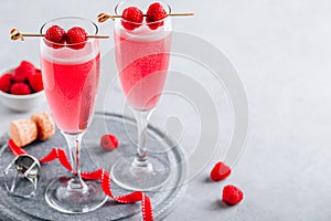 Pink cocktail with champagne or prosecco and fresh raspberries for  Valentine day