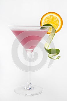 Pink cocktail with lime and sliced orange