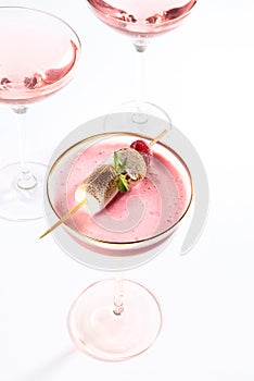 Pink cocktail in a tall glass. The alcoholic cocktail is decorated with marshmallows. Photo on white background. Close