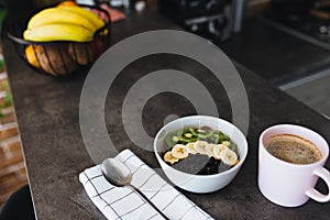 Pink coffee cup, bowl with chopped fruits and blueberries, spoon in kitchen