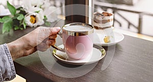 Pink coffee cup on the table in cafe over the window