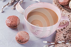 Pink coffee mug with sweet pastel french macaroons and wil