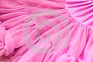 Pink color chiffon fabric folds. Rose dress with ruffles and frills