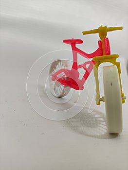 pink color toy bike standing on white background isolate
