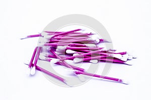 Pink colored cotton coated ear buds or Q-tips isolated on white.
