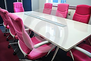 pink conference chairs around a white meeting table, nobody present