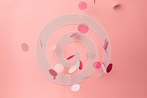 Pink confetti on pink background. Copyspace for text. Bright and festive holiday background