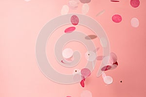 Pink confetti on pink background. Copyspace for text. Bright and festive holiday background