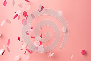 Pink confetti on pink background. Copyspace for text. Bright and festive holiday background