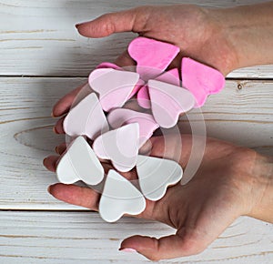 Pink cookies in woman hands, heart shape, white background