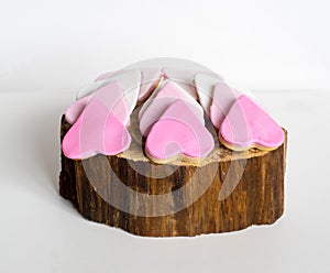 Pink cookies on the wooden old tree cut, heart shape, white background