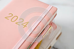 Pink coral colored diary for the year 2024, pen, marble background