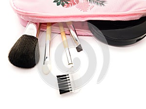 Pink cosmetic bag with brushes and powder isolated on white background. Makeup kit.