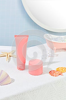 The pink cosmetic set is displayed on a white fabric background with seashells. Cosmetic mockups for branding and advertising.