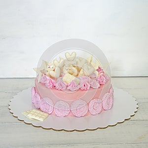 A pink creamchease cake with flowers for 5 year birhtday