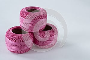 Pink crochet yarn against white background, space for text