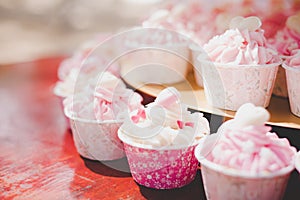 Pink cup cakes in wedding ceremony. Decoration and Celebration concept. Food and Dessert theme