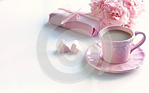 Pink cup with coffee, marshmallows hearts, gift and bouquet of pink roses