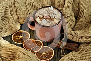 Pink Cup of hot chocolate with marshmallows on knitted background. Winter mood