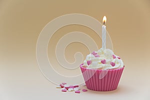 Pink cupcake with burning candle