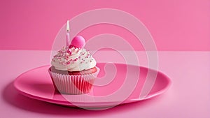 pink cupcake with candle A pink birthday cupcake with white frosting and a candle on a pink plate. blank empty background,