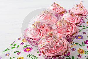 Pink cupcakes on floral napkin