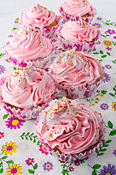 Pink cupcakes on floral pattern napkin