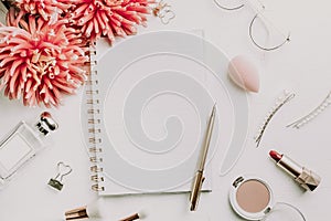 Pink dahlia flowers and notepad on white background